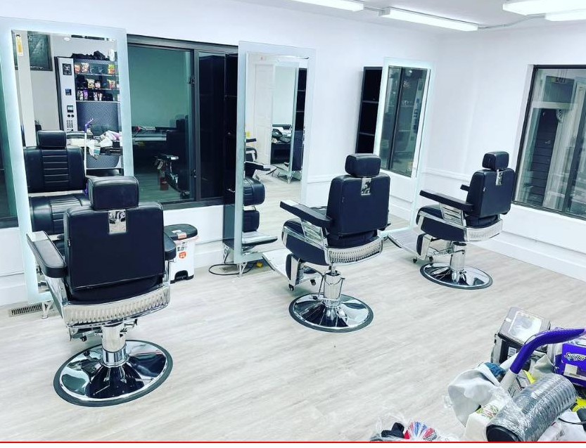 Interior of Unlimited Barbershop in Danbury, CT, with classic black barber chairs and bright mirrors