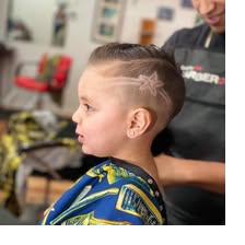 Kid's fade with a freehand design line at Unlimited Barbershop